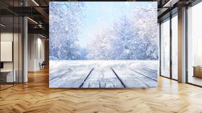 Winter Christmas scenic landscape with copy space. Wooden flooring, white trees in forest covered with snow, snowdrifts and snowfall against blue sky in sunny day on nature outdoors, blue tones. Wall mural