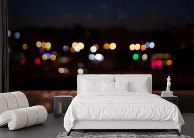 Empty wooden table with blurred cityscape, blurred city lights reflected on wooden background. Empty background template with bokeh Wall mural