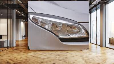 Car's exterior detail,new headlight on a  white silver car Wall mural