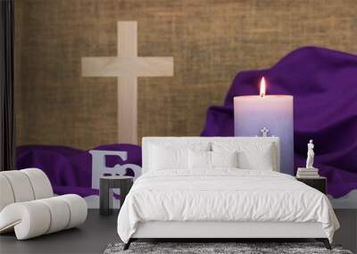 Purple Easter candle burning with the word Faith and blurred wood cross in background Wall mural