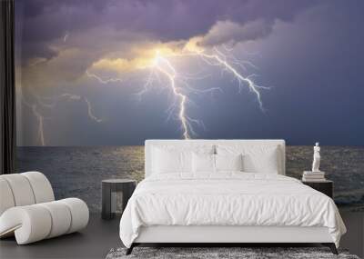 a calm sea under a light storm, with gentle waves and distant lightning illuminating the soft clouds in muted purples and grays. Wall mural