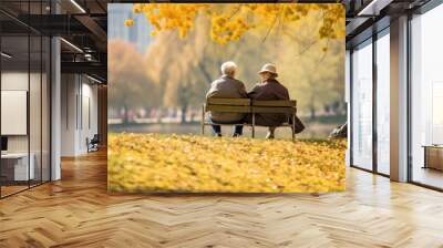 Photo of two old people, sitting on a bank in an autumn park Wall mural