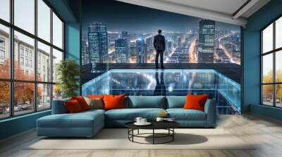 Rear view of businessman standing on rooftop and looking at night city Wall mural