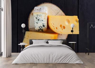 Hard cheese and blue cheese on wooden stand. Different types of cheese on black boards. Swiss cheese and dorblu on dark background Wall mural