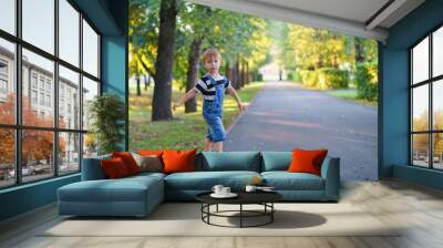 Boy walking in the park along the alley Wall mural