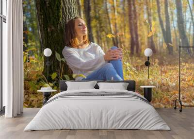 Girl sitting under a tree in the forest Wall mural