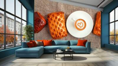 a cup of coffee on a saucer and cakes in a row on a gray backgro Wall mural