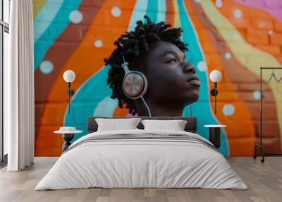 Black man wearing casual attire listening music on bright background. Portrait of man with headphones against colored backdrop Wall mural