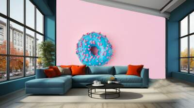 Blue donat decorated sprinkles and icing on a pink background. Creative and minimalis food concept, top view flat lay Wall mural