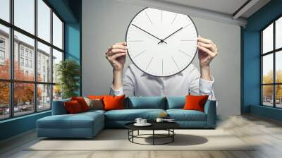 business woman covering her face with clock Wall mural