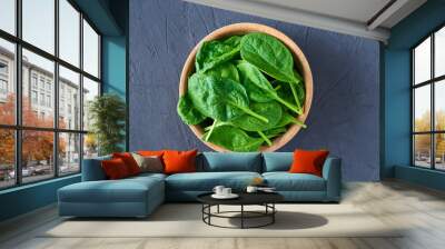 Fresh spinach leaves in wooden bowl on dark background. Organic food Wall mural