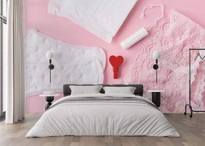 Sanitary pad, menstrual cup, tampon and panties on a pink background Wall mural