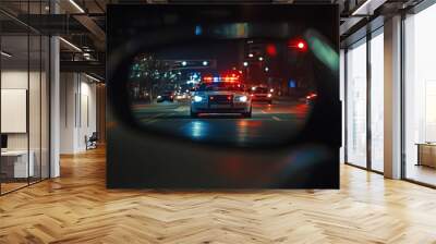 View from rearview mirror on police car with flashing lights is driving on city street at night Wall mural