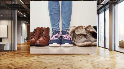 Woman chooses comfortable brown leather shoes among bunch of the different pairs Wall mural