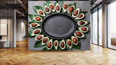 Avocado and avocado tree leaves frame around empty plate. Copy space food background Wall mural