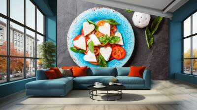 Caprese salad with tomatoes, cheese hearts, basil. Valentine day menu Wall mural