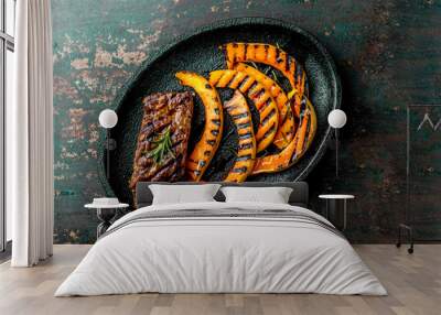 Grilled meat and pumpkin on black plate. Autumn menu. Top view Wall mural