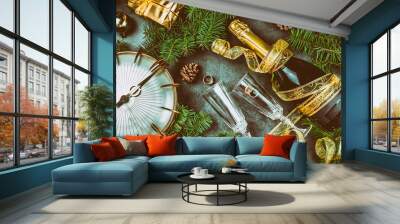 New Year Eve tradition rutual put gold ring to champagne. Spanish and Latin American New year traditions. Two champagne grasses, bottle of champagne, vintage clock and Christmas decorations. Top view Wall mural