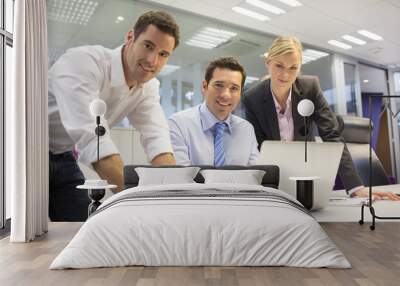 Portrait of cheerful business team in office, looking camera Wall mural