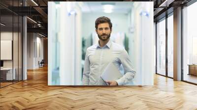 Portrait of handsome bearded business man in corridor office Wall mural