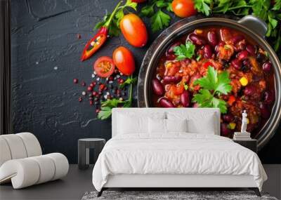 A bowl of chili with a variety of vegetables and spices on a black background Wall mural