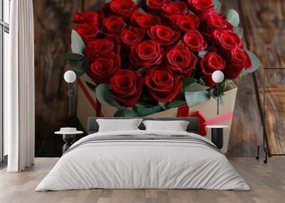 Gift box with red rose flowers bouquet above on dark wooden table. Generate AI Wall mural