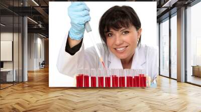 biologist, holding a pipette with sample from test tubes. Wall mural