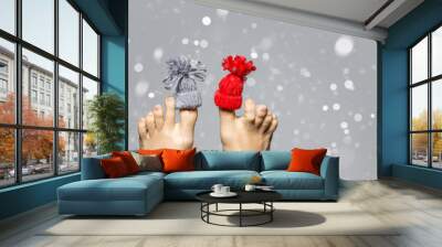 Funny playful female feet with small knitted hat on big fingers Wall mural