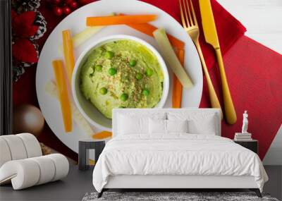 Green pea hummus with carrot and pepper crudites. Top view table with Christmas decorations. Wall mural