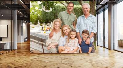 Portrait of smiling multi-generation family at table in garden Wall mural