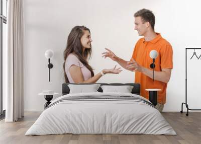 Happy lovely couple smiling and talking to each other about something. Studio shot over white background Wall mural