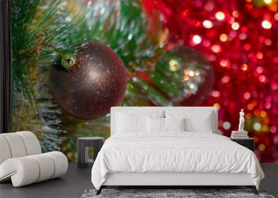 Christmas banner: a brown and gold Christmas ball weighs on a branch of a Christmas tree against a background of red tinsel and Golden balls. The view from the top, place for text. Wall mural