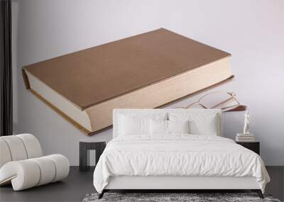 book and glasses on a white background Wall mural