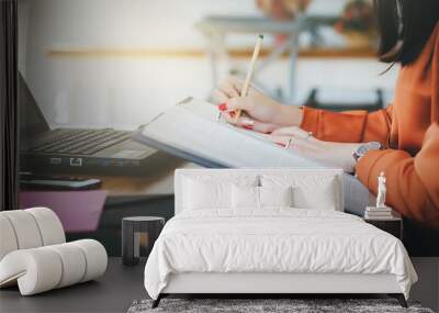 Closeup of hand asian businesswoman writing on document and working with laptop in office Wall mural