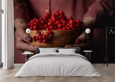 Hands with  red berries close-up. Fall season. Autumn mood., mountain ash Wall mural