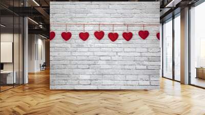 Red handmade textured hearts hanging on a rope on a white brick wall background. Image of Valentines day, birthday, love consept. Wall mural