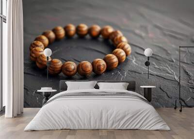 A close-up of a wooden bead bracelet on a black slate background Wall mural