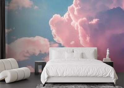 Pink clouds float against a clear blue sky Wall mural