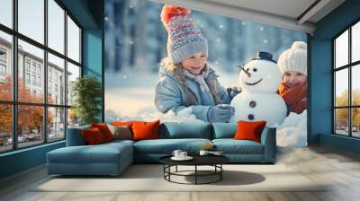 Cute children building a snowman in winter in forest. Girls in december playing in snow Wall mural