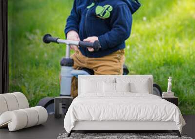 Cute baby boy on his first running bike Wall mural