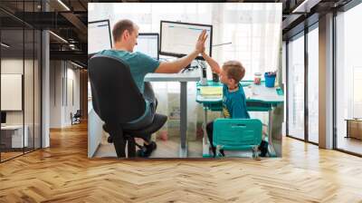 Father with kid working from home during quarantine. Stay at home, work from home concept during coronavirus pandemic Wall mural