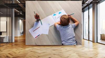 Little boy drawing on the floor in his room Wall mural