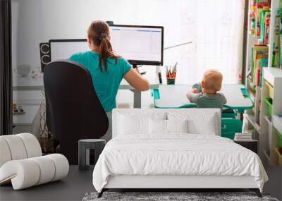 Mother with kid working from home during quarantine. Stay at home, work from home concept during coronavirus pandemic Wall mural