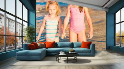 Two adorable kids playing in the sea on a beach Wall mural