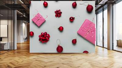 Gray background with two pink Christmas gift boxes, red ball toys, spheres, bows Wall mural