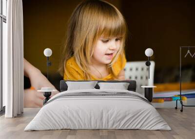 nice little girl in the yellow dress drawing with wax pastel Wall mural