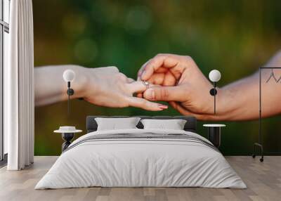 Man making proposal with the ring to his girlfriend. Put ring on hand. Wall mural