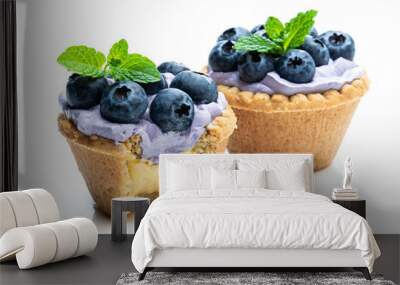 Mini tarts with blue cream and fresh blueberries isolated on white background Wall mural