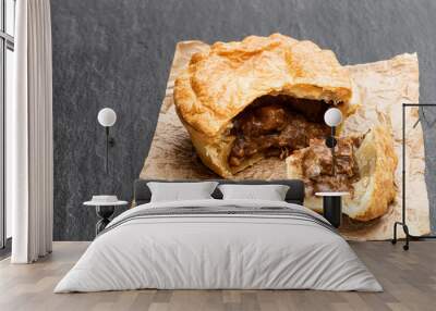 Puff pastry steak pie on baking paper on black stone backgroung Wall mural