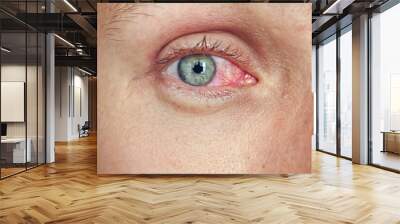 Close-up of a male face with red eyes. Wall mural